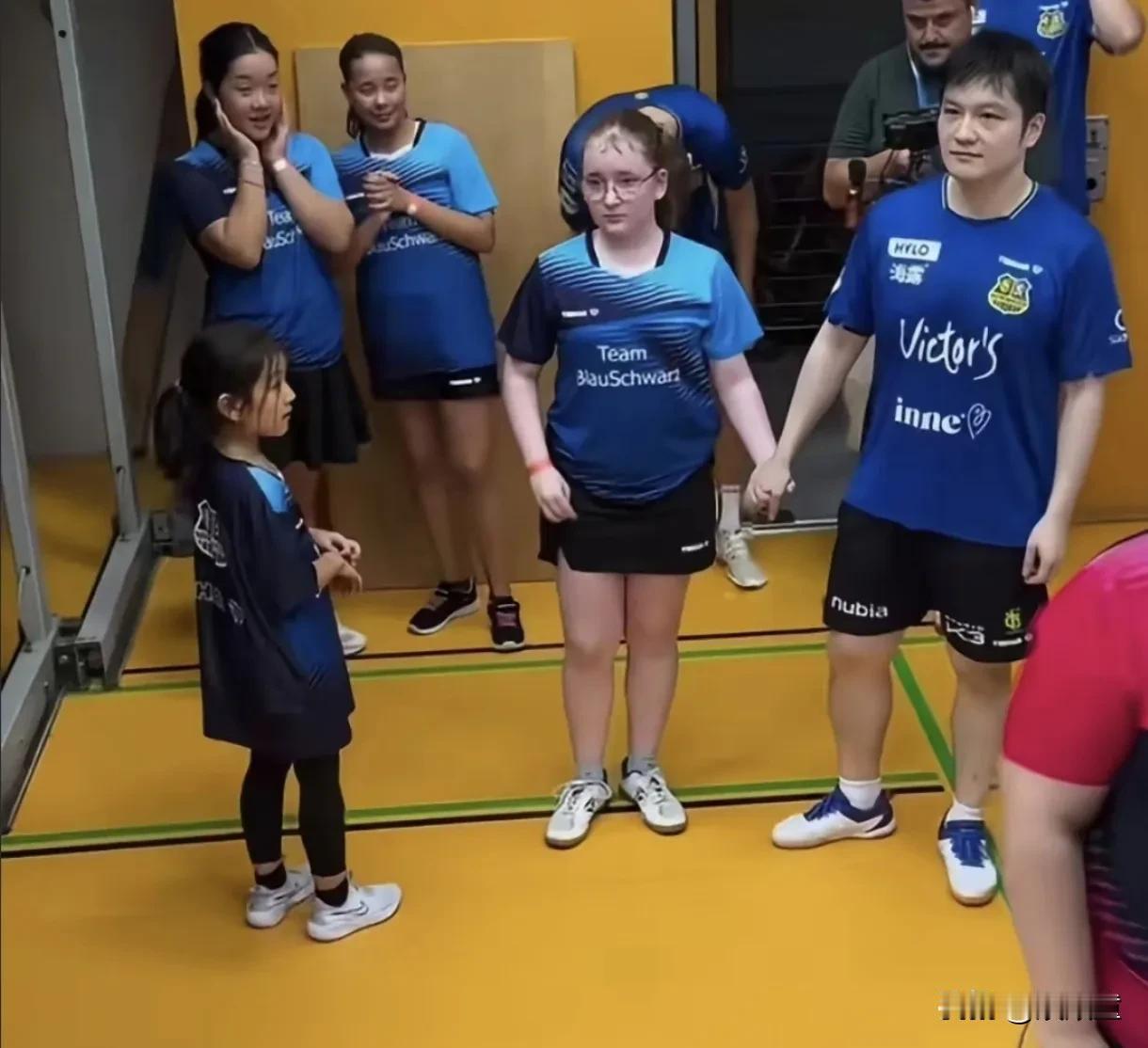 不止我们羡慕牵手樊振东的小女孩，国外的孩子也羡慕，也想牵手这位外国来的帅哥哥！