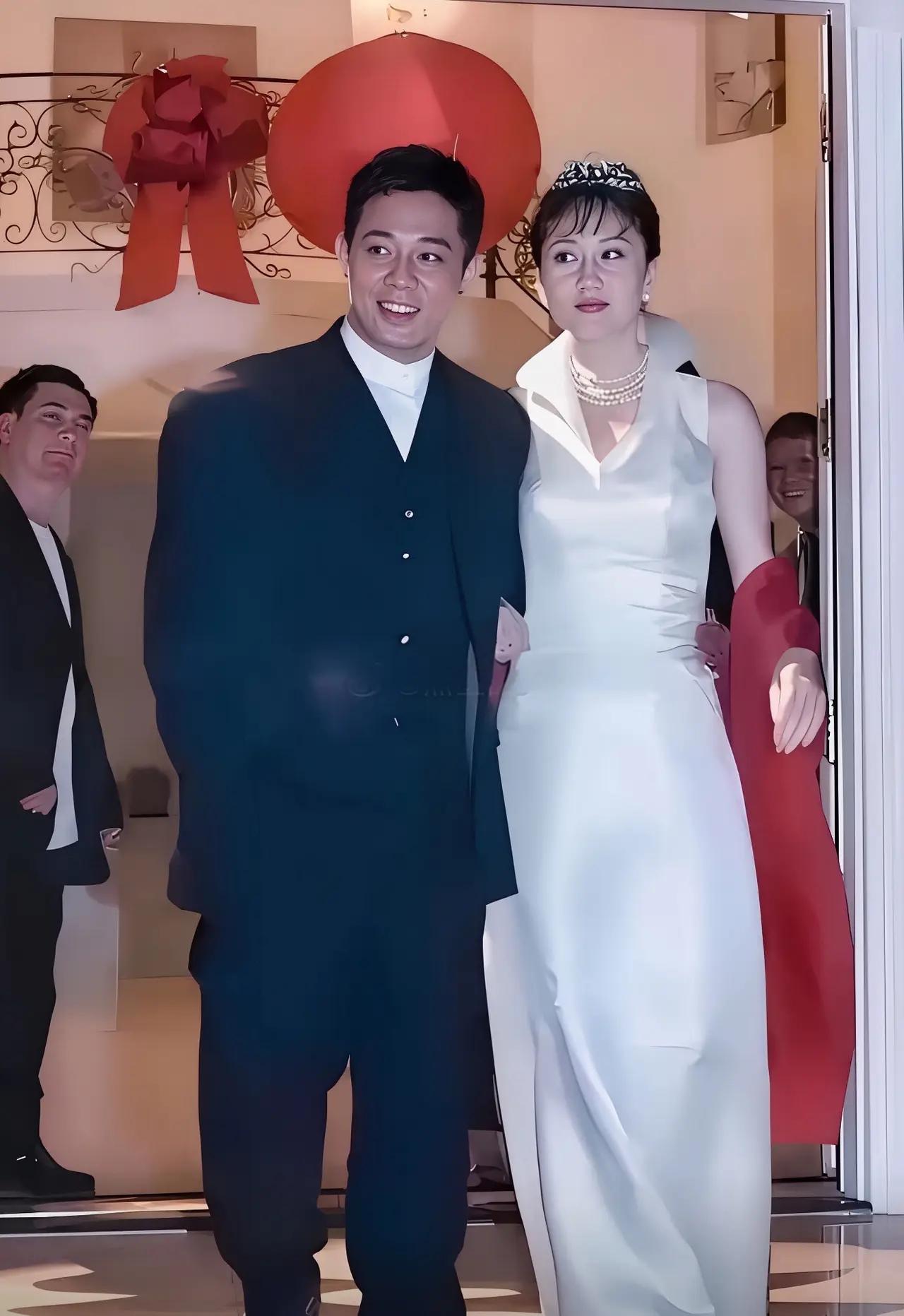 99年洛杉矶，
36岁的李连杰，旁边38岁的利智穿着白色的婚纱挽着他胳膊，一脸的