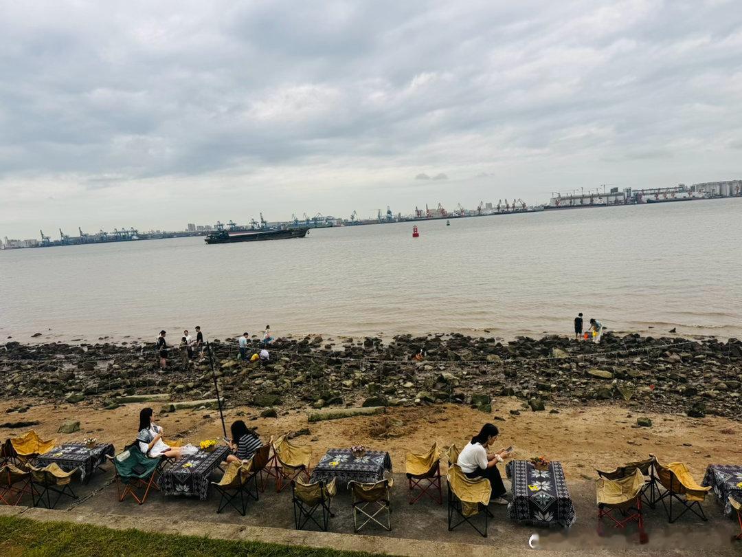 海边，阴天，微风拂面，听滚滚海浪拍岸的声音，小朋友们在捡贝壳，捉螃蟹，玩得很尽兴