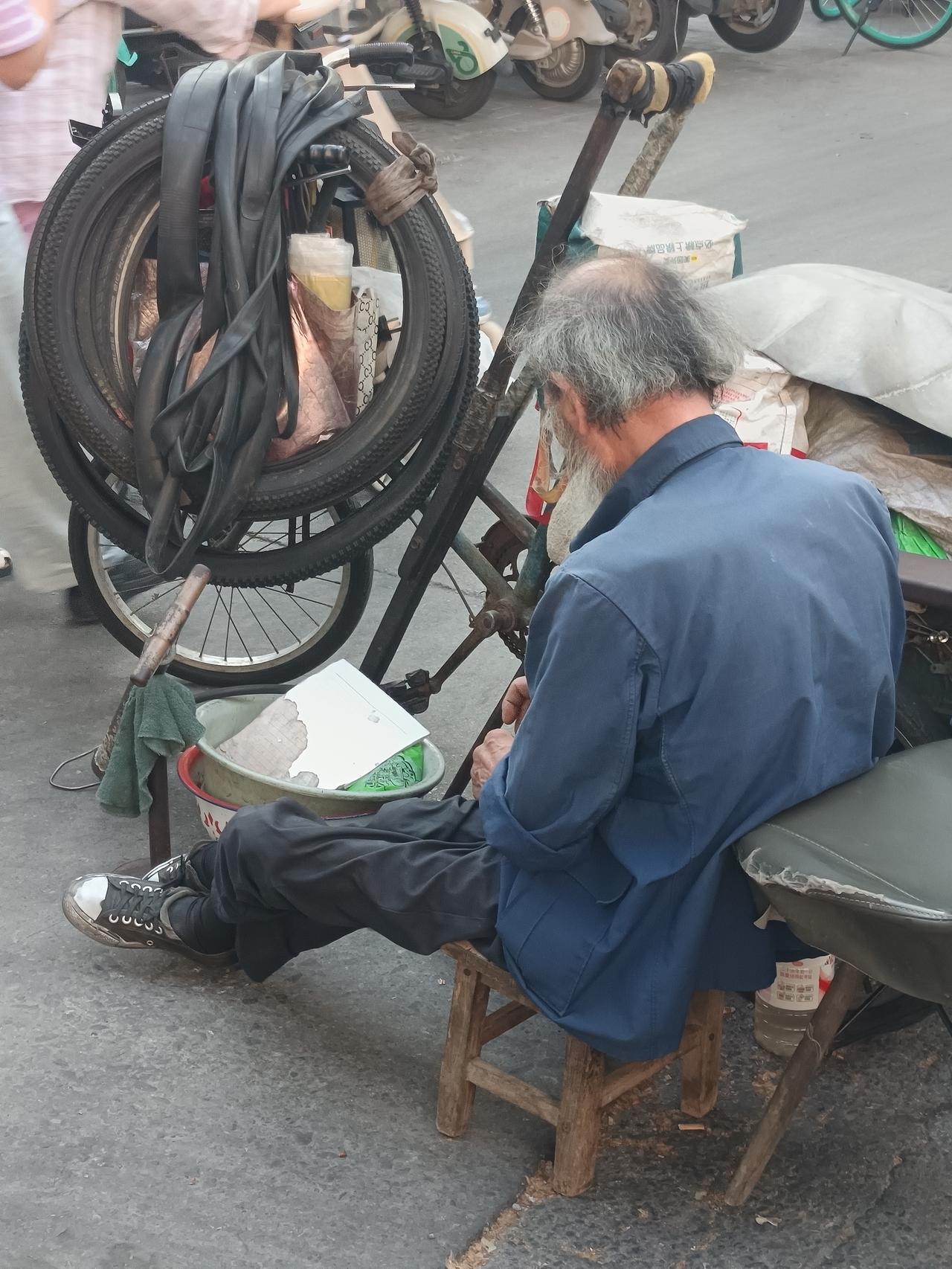 胡家庙天桥下，一位80岁的残疾老人，还在坚持工作，修自行车，补车胎，值得年轻人学