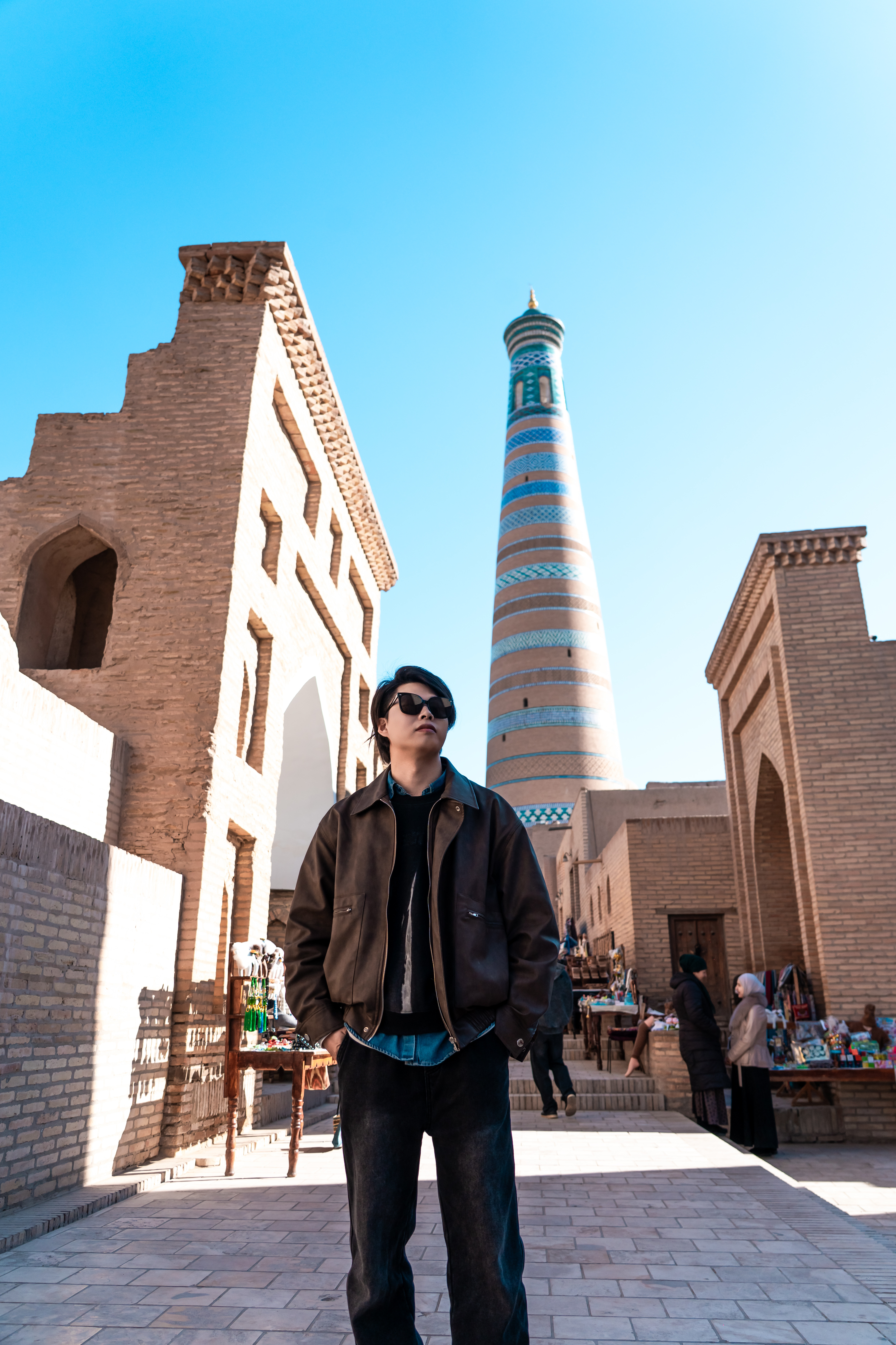 指尖划过希瓦城墙的粗粝，触摸的仿佛是时间本身的肌理。🕌那些未能参天的宣礼塔，何