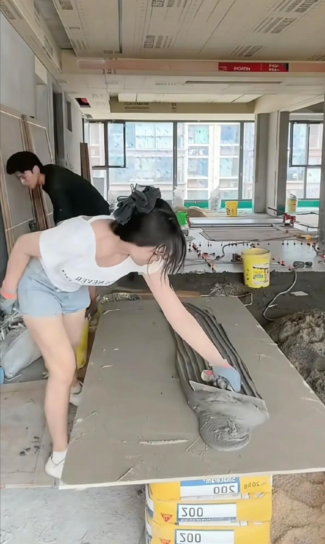 又一次相信爱情了
近日被一对贴瓷砖的河南00后小夫妻圈粉了
丈夫砌砖，妻子和水泥