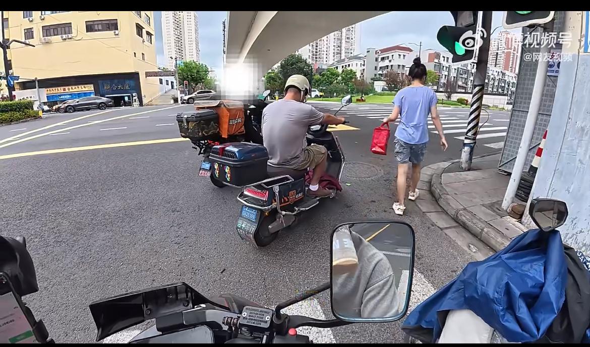 红绿灯路口一外卖员抽烟，被旁边几米远的女子指责，说刺鼻的烟味影响到她了，外卖员反