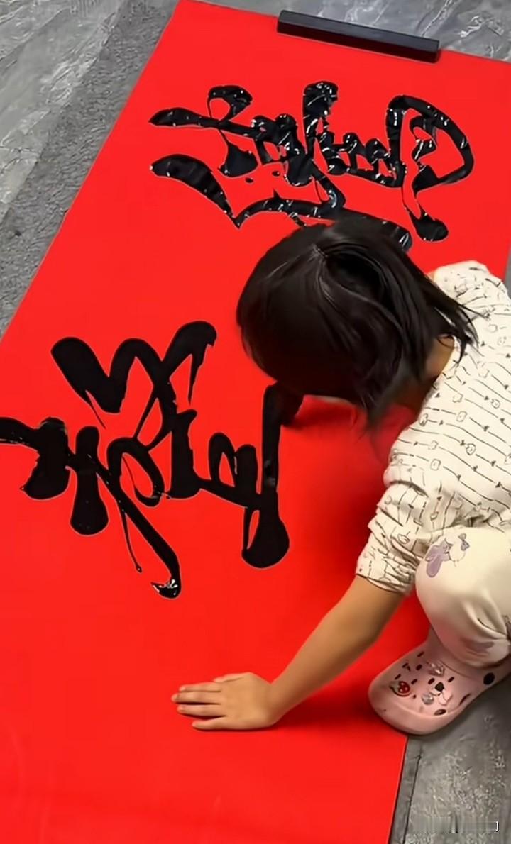 这小女孩蹲在红纸上挥毫泼墨的模样，直接打了多少所谓名家的脸。没有刻板的馆阁体，没