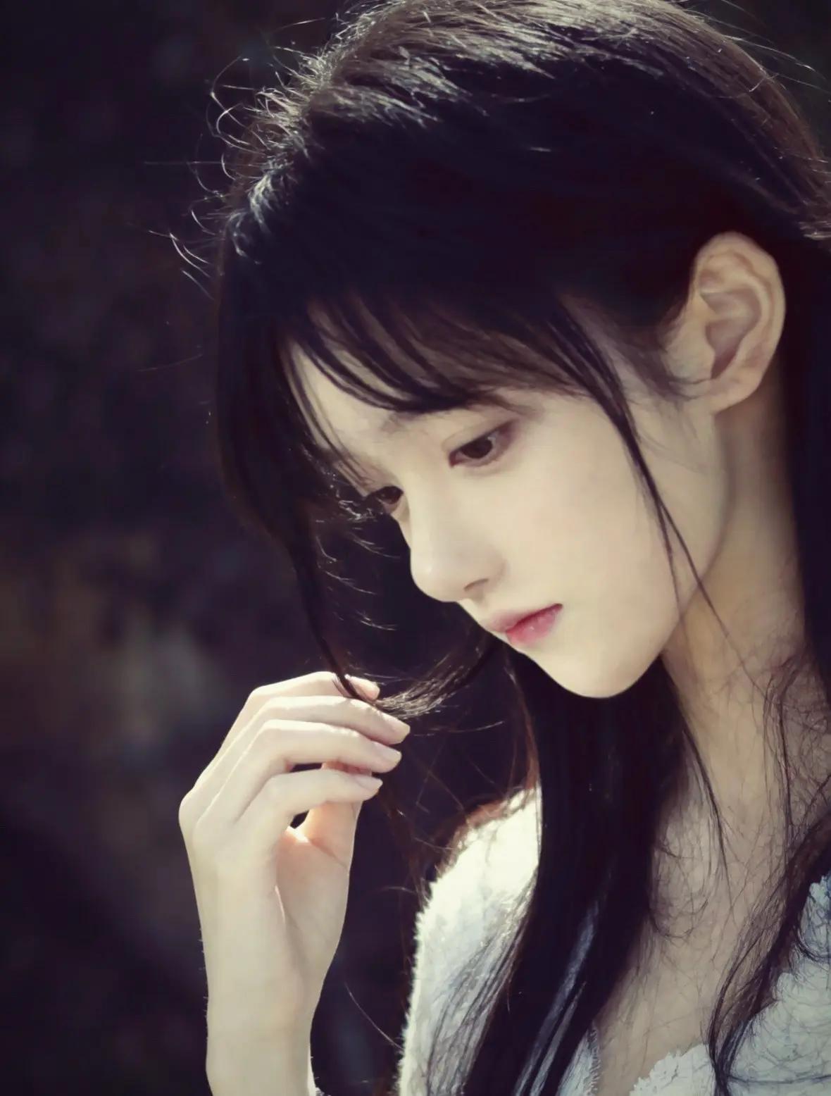 这低眉垂眸的瞬间，眼神里全是故事，像极了青春疼痛文学的女主角。光影打在脸上，那种