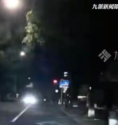 深夜的公路光线昏暗，车主正常开车往前走，对面车道有辆车不停按喇叭，还反复闪远光灯