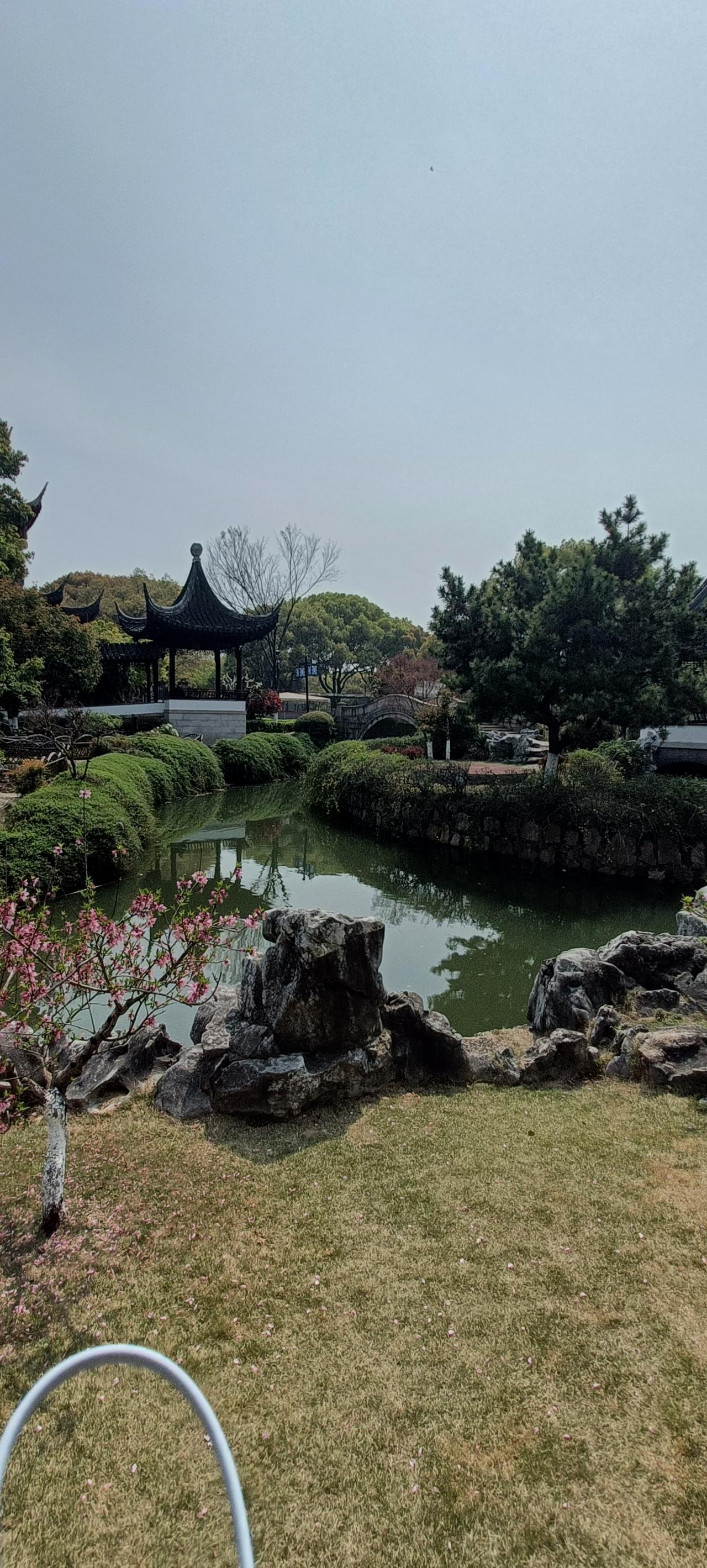 宁静的园林，亭台楼阁，绿树成荫，粉花点缀，仿佛置身世外桃源。
上联:曲径通幽处，