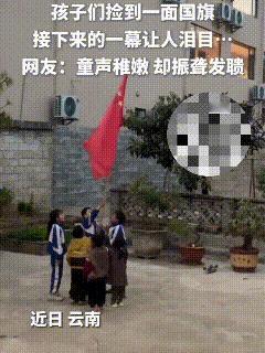 近日，云南，一群孩子们在外玩耍，期间一个孩子看到一面国旗在路上躺着，他毫不犹豫跑