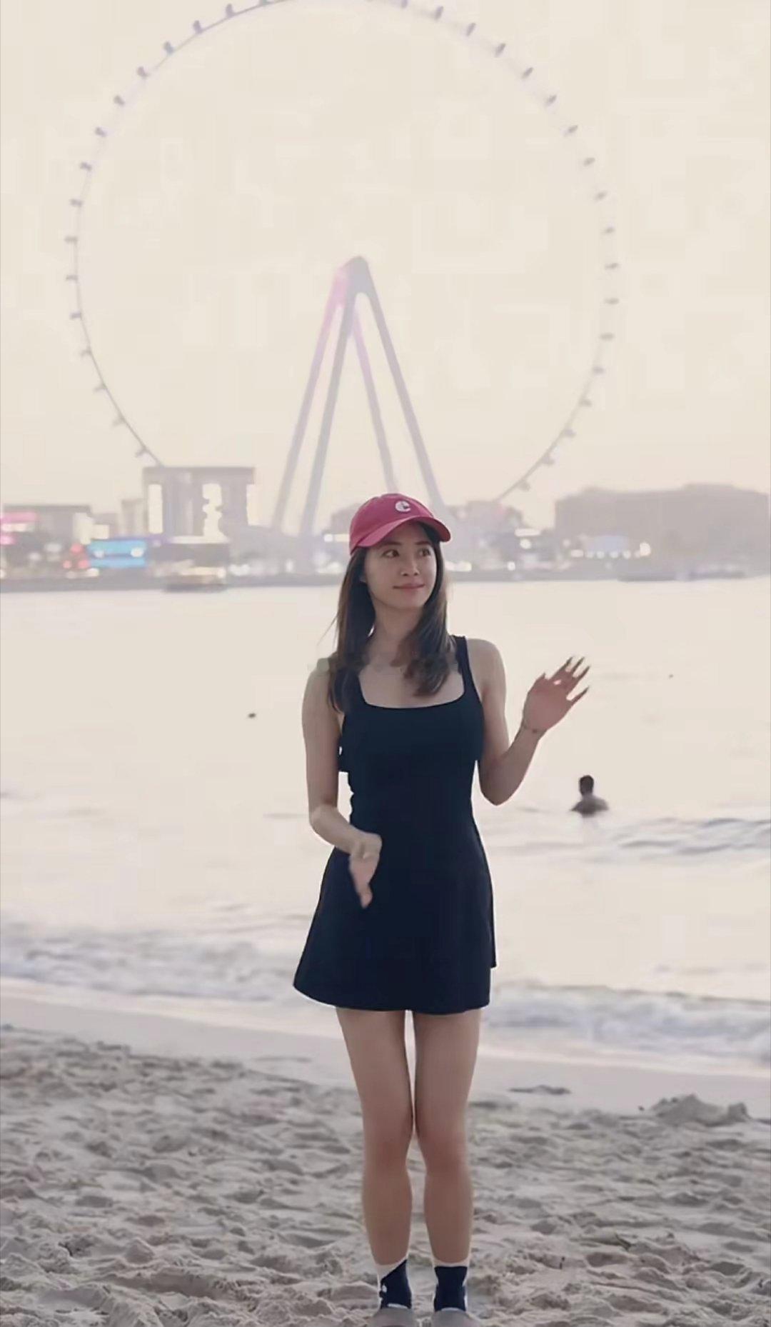蔡依林在海边尽情舞动，头戴棒球帽搭配俏皮的吊带裙动感又迷人。双腿又细又长身姿轻盈