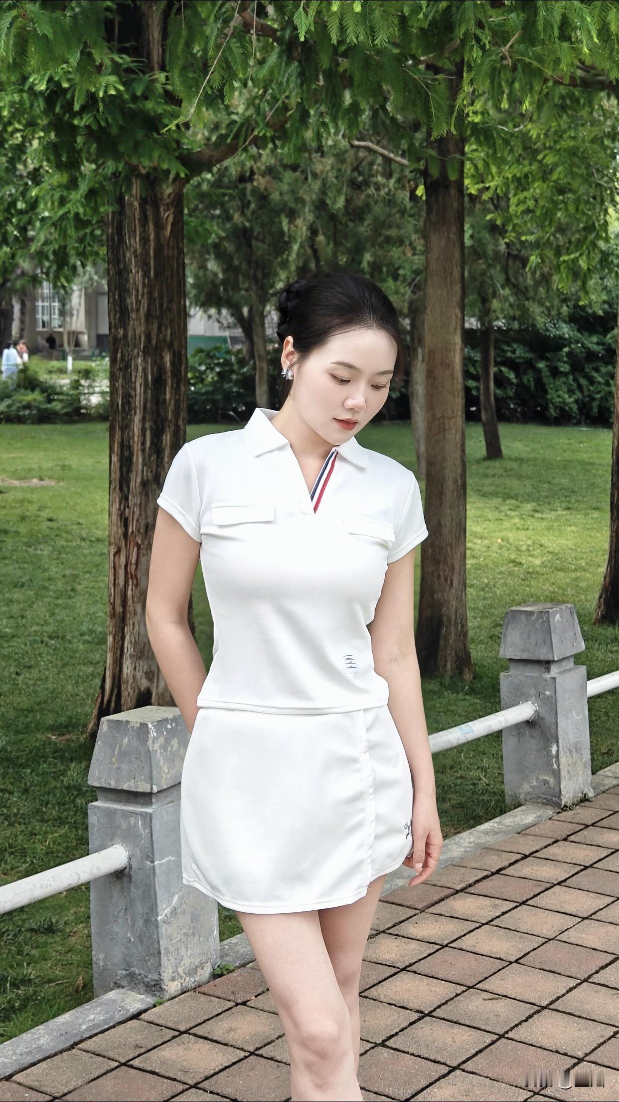 怎样穿搭能显示出温柔的女生气质?夏日清新穿搭，白色连衣裙与绿树相映成趣，尽显优雅