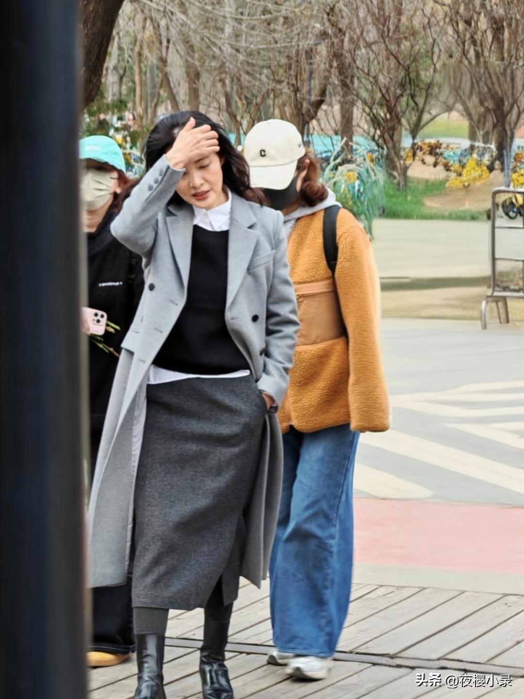 58岁周涛现身北京朗园游玩，她穿着灰色大衣和长筒靴，一头长卷发披肩，看起来贵气十