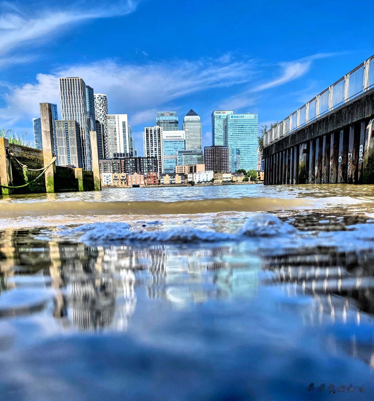 清晨九时的泰晤士河，早潮汹涌，河滩与斜道都被淹没。北岸狗岛在水汽中若隐若现、似远
