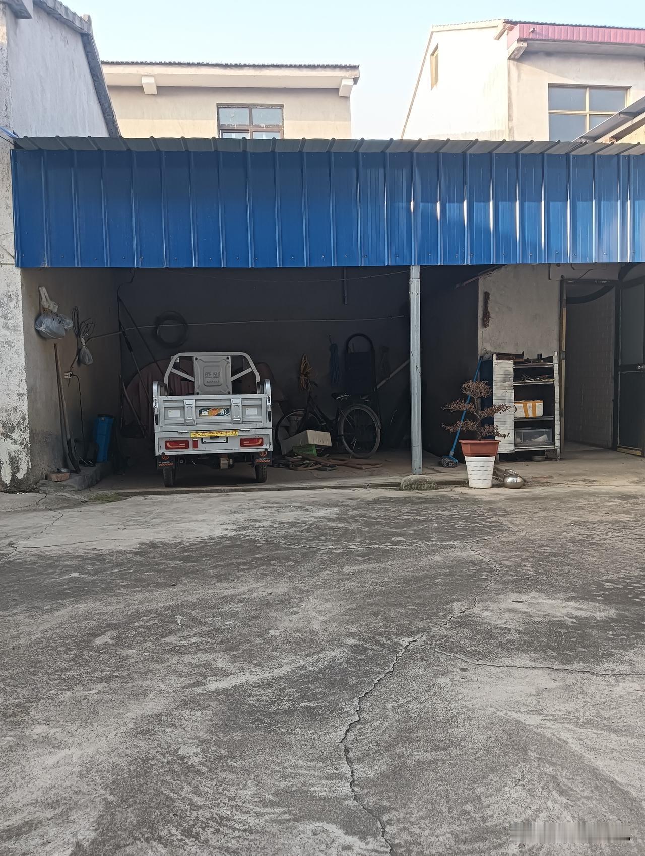 车库前停着一辆老旧的小货车。