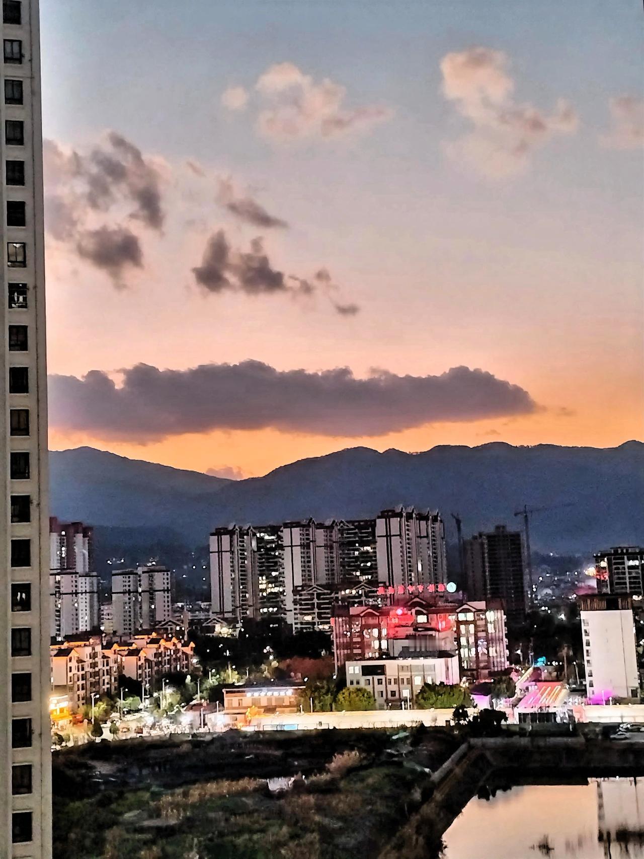 路过公园，里面的树木在路灯下投下斑驳的影子。老人们坐在长椅上悠闲地聊着天，孩子们