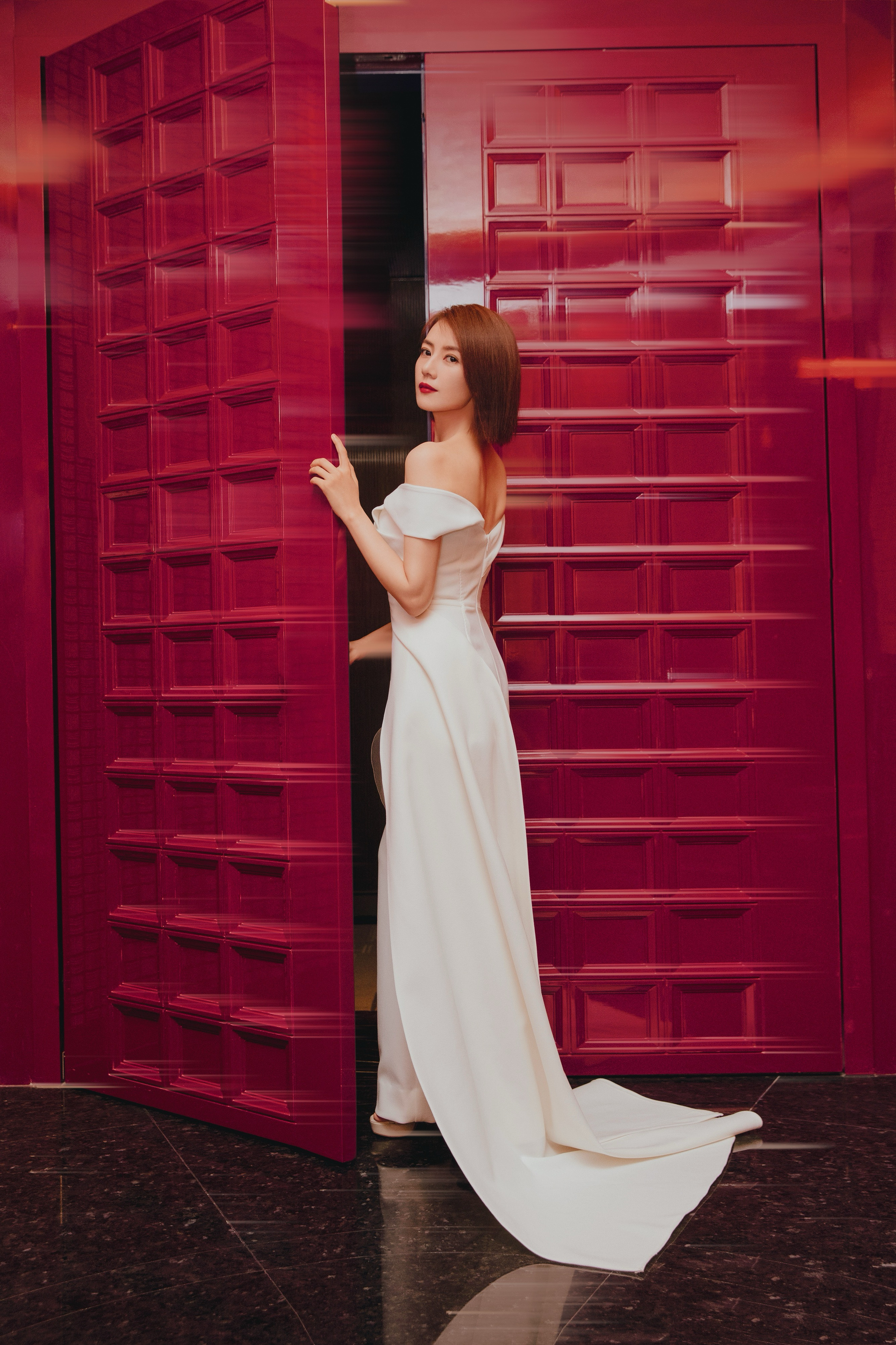 白色系裙装将她的优雅与知性展现得淋漓尽致。透着一种岁月沉淀后的从容美感。 