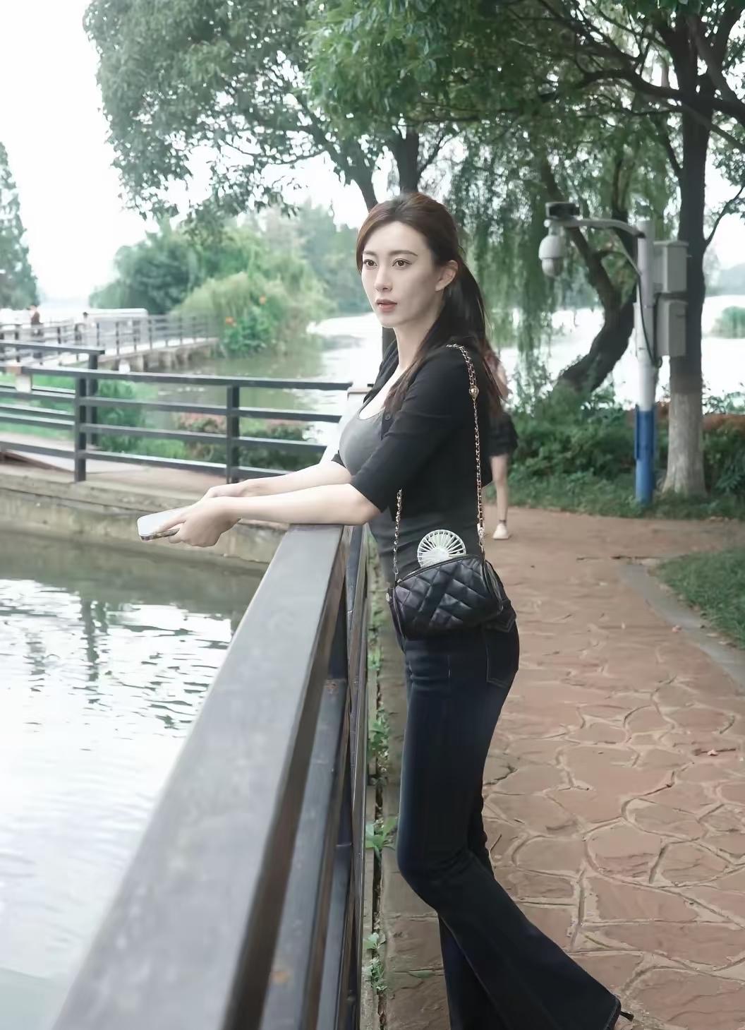 这位女士靠在河边，看起来好惬意。