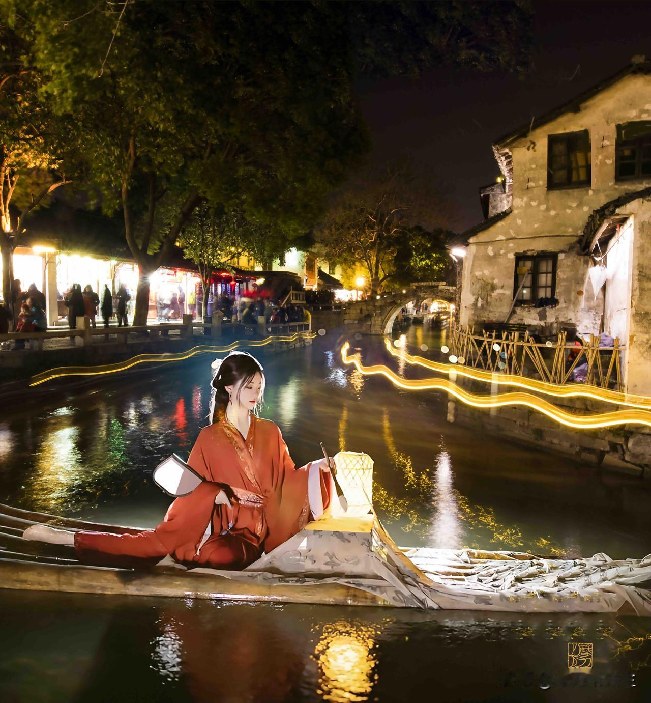夜色染西塘，灯影摇波。着一袭红衣，乘竹筏入画，灯盏映水，笔尖轻落，便晕开千年江南