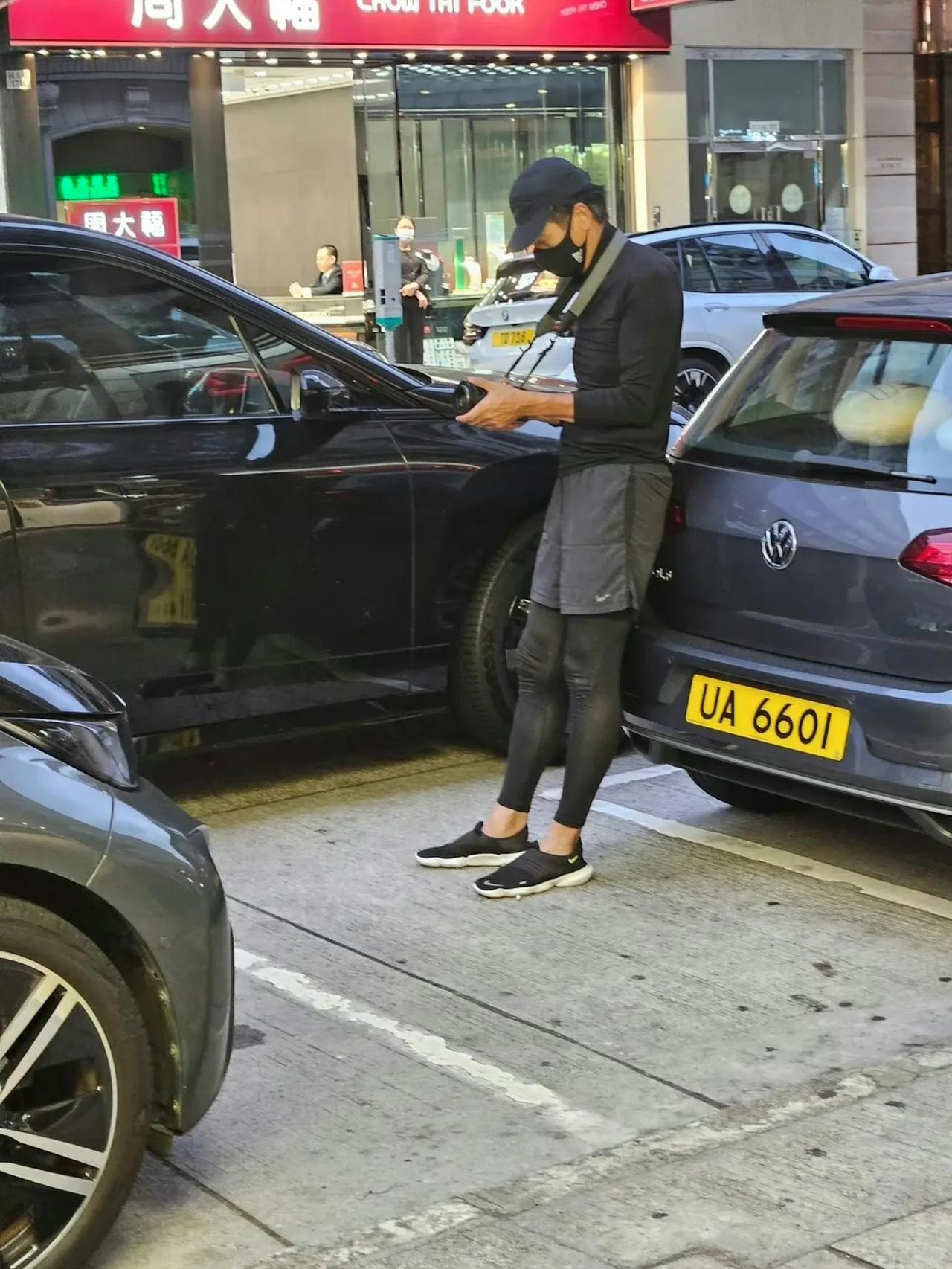 街頭，一名喜歡攝影的黑衣男子引起路人的注意。