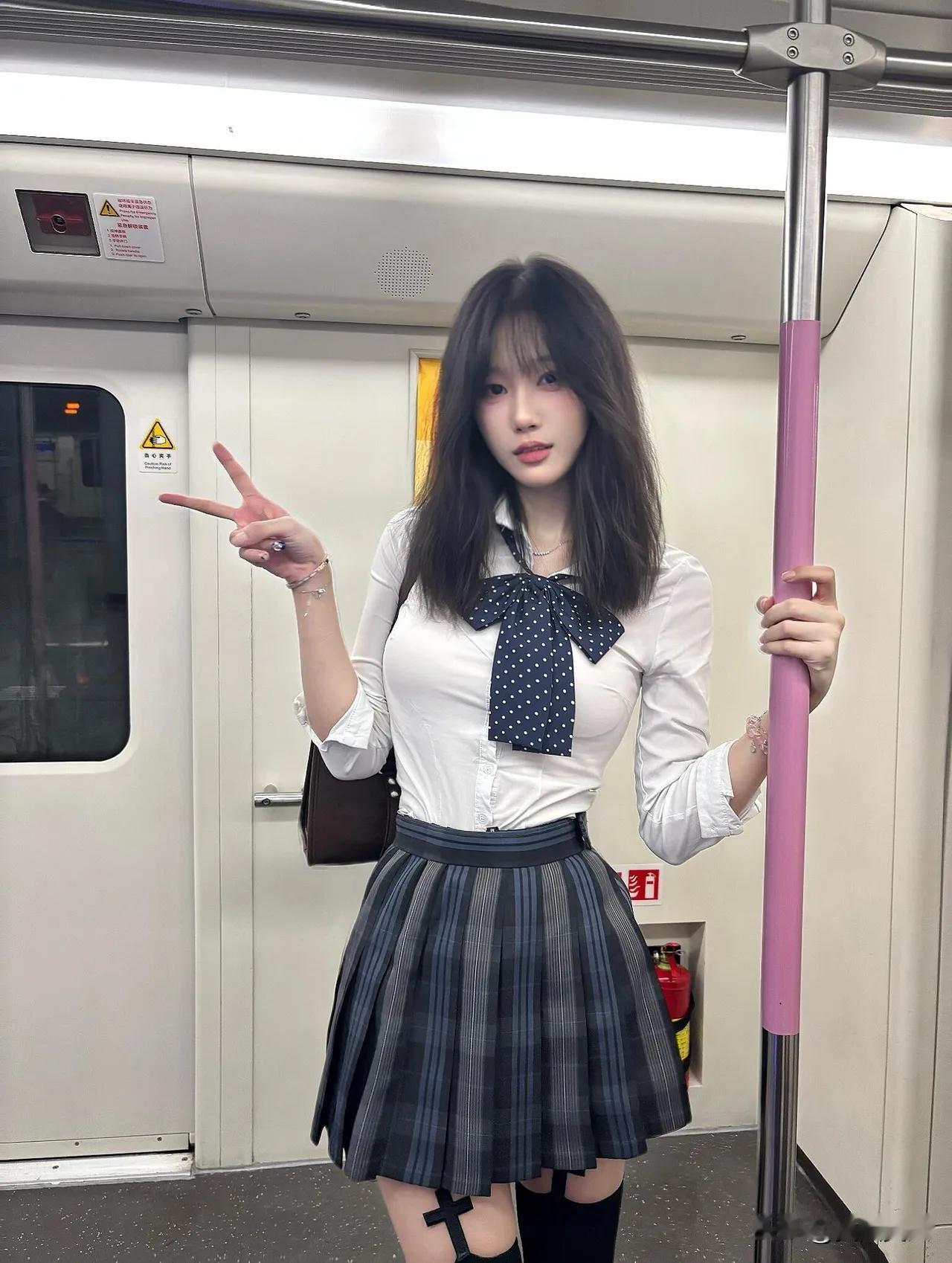 地铁晃动的车厢里，白衬衫裹着松弛的少年感，格裙裙摆轻晃成流动的青春注脚。波点领结