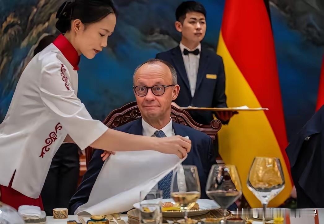 这女士在宴会上尤其亮眼。在25日为德国总理一行举行的北京国宴上，为默茨总理服务的