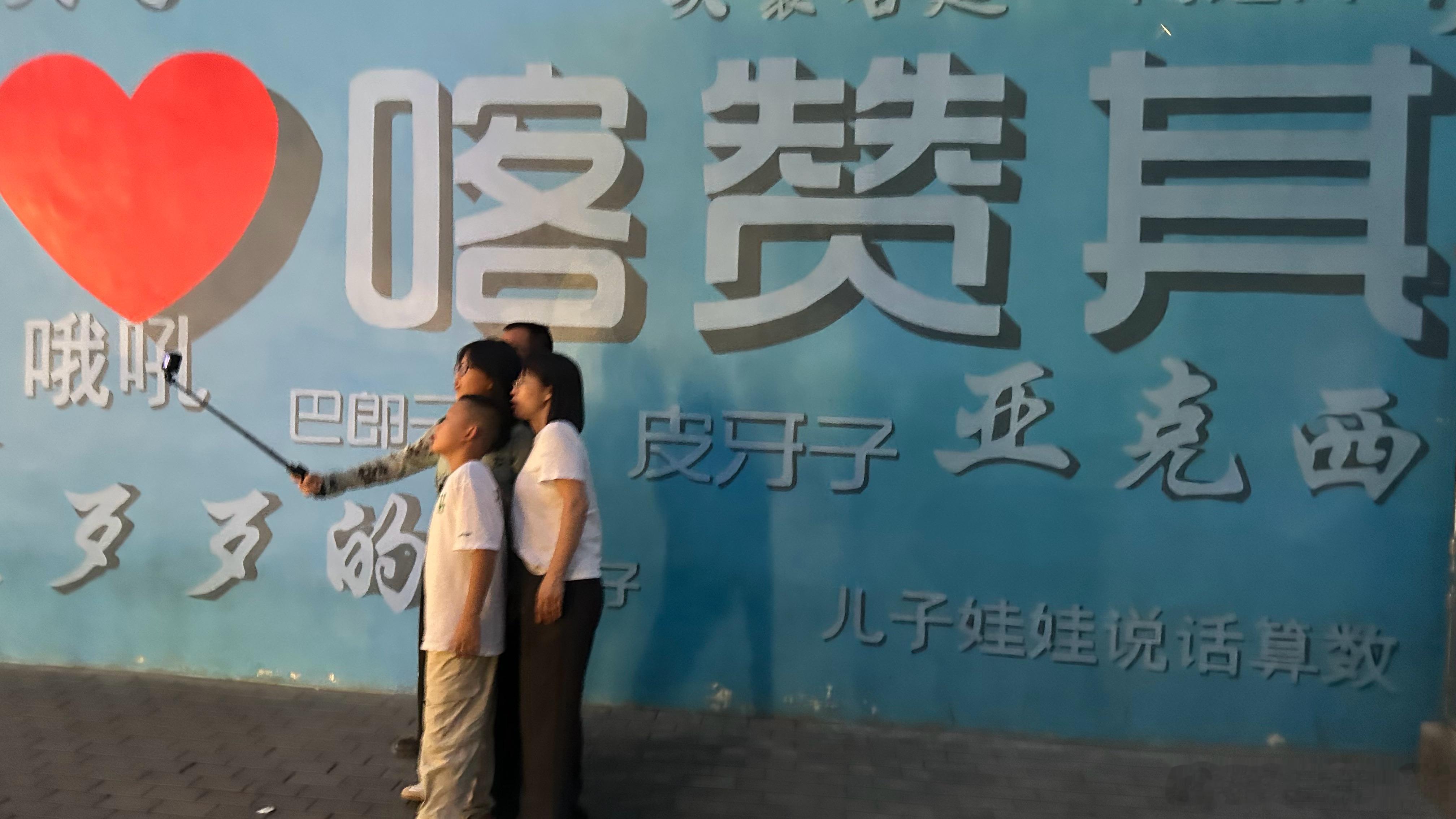 前天，我们开车路过这里，我看到这一家四口正在“我喀赞其”这里自拍全家照，立刻抓拍