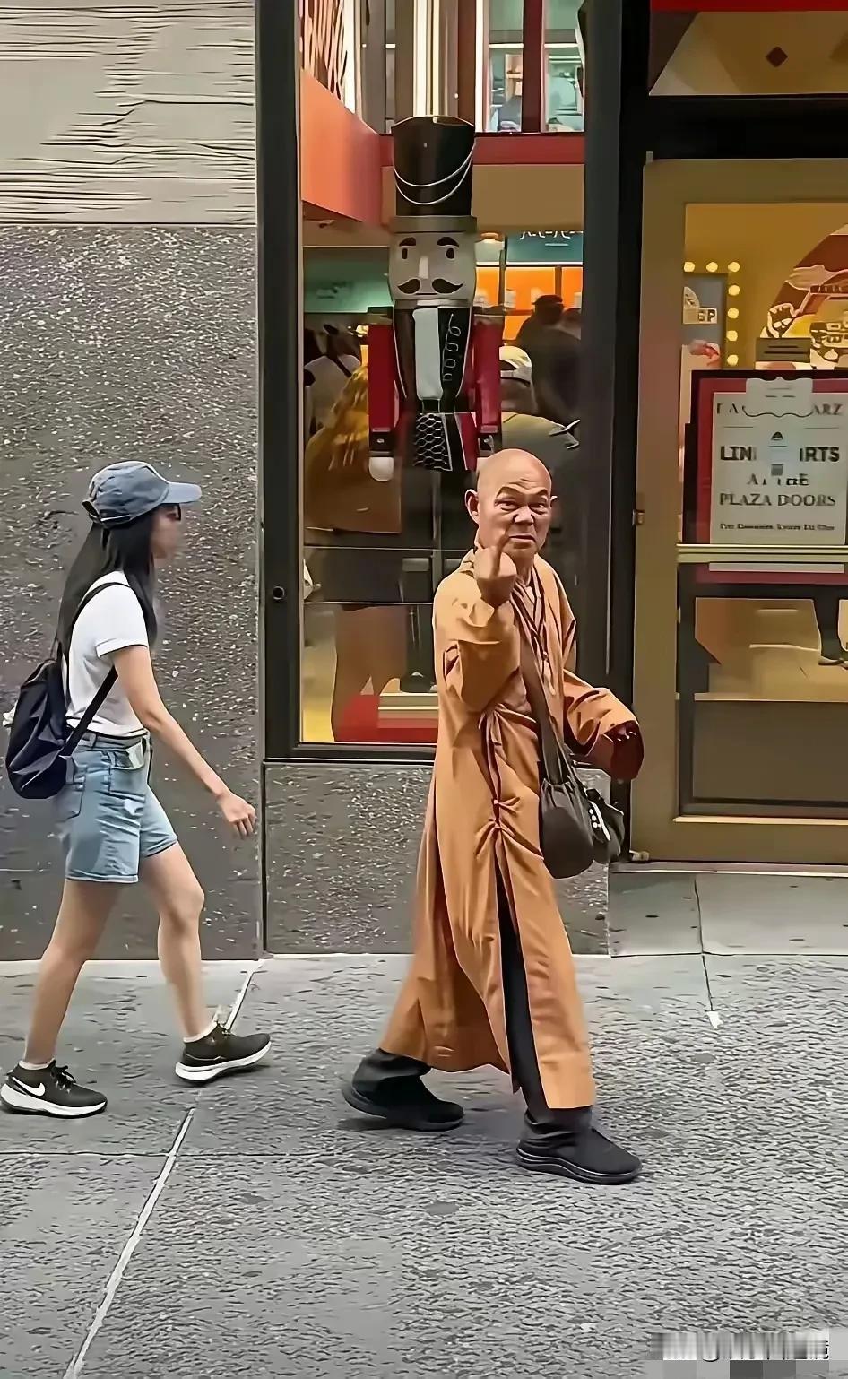 照片中这个肯定是个假和尚。
不仅面目可憎，还向人竖中指，和地痞流氓有什么分别，这