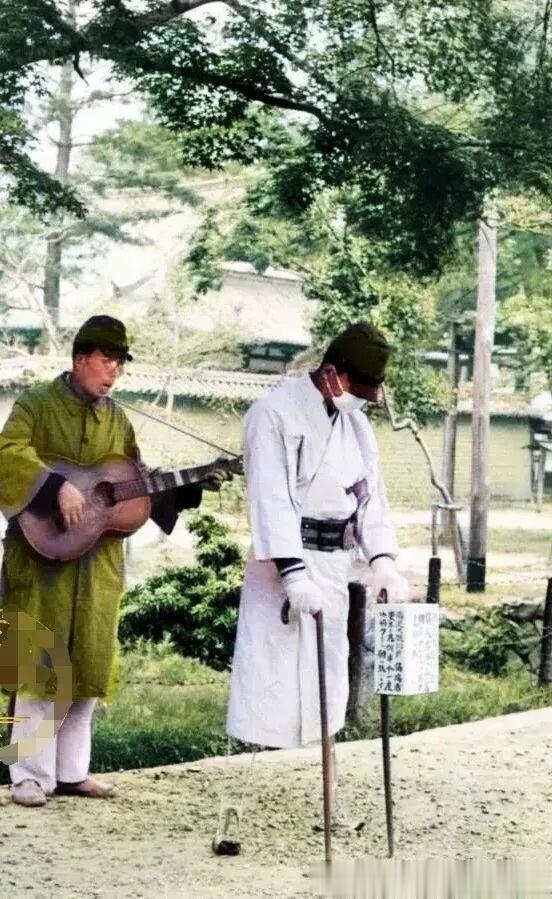 50年代，两名日本老兵身穿军服在街头乞讨的照片，照片中的两名日本人还身穿侵华战争