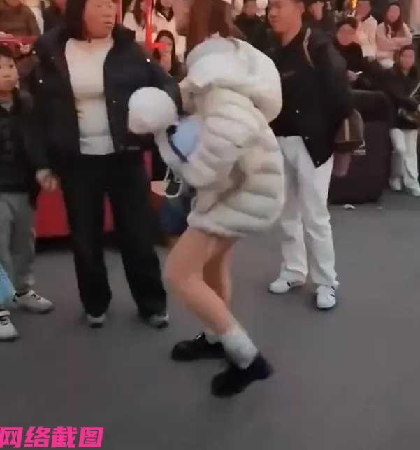 有女子带着自己的宠物狗，在一处景区看场景表演，只是女子没有想到自己的狗狗伸出舌头