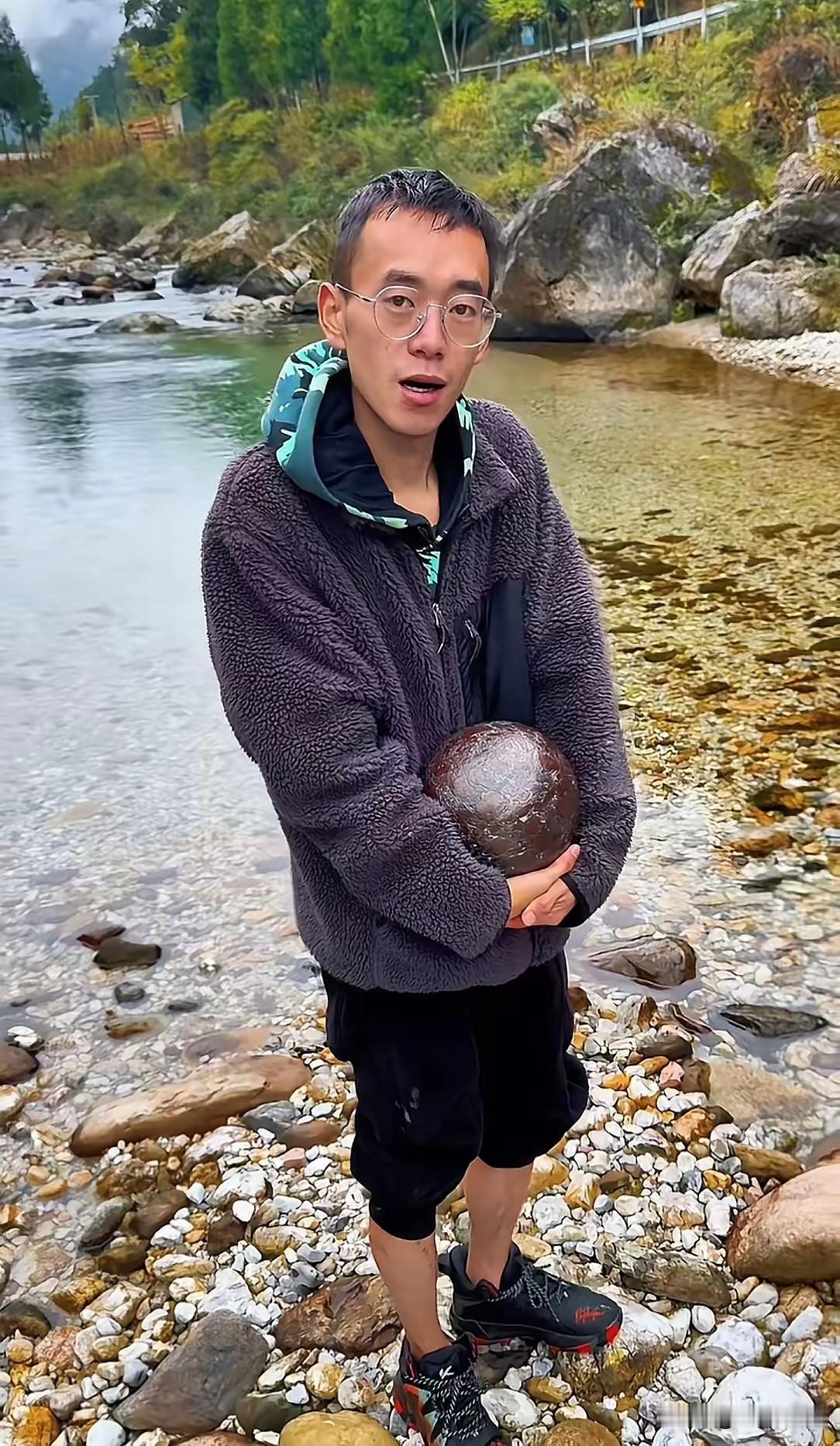 男子在河边捡的这个石头球子，感觉不像是天然形成的，像是经过加工而形成的，从品相上