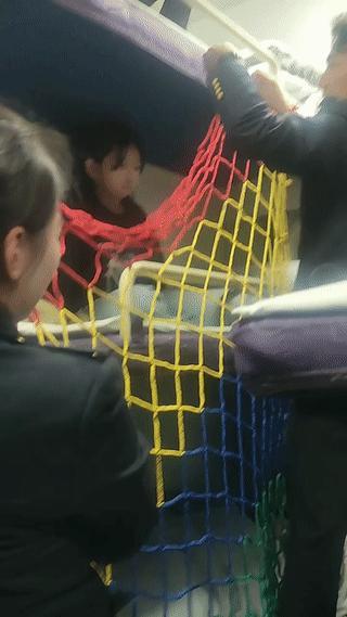 一名小女孩睡火车中铺。
列车员担心小女孩半夜睡觉翻身时有可能会掉下来！
为此还专