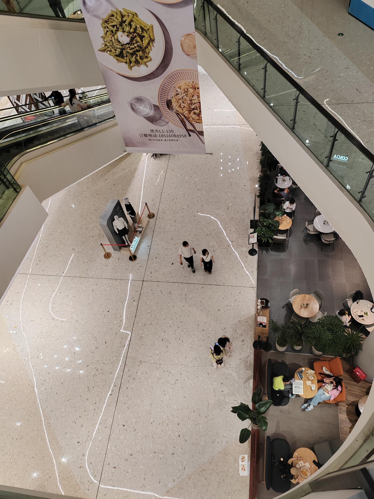 从俯拍视角看商场的日常，光和影像两个调皮的小精灵，在光洁的地砖上欢快地流转。人们