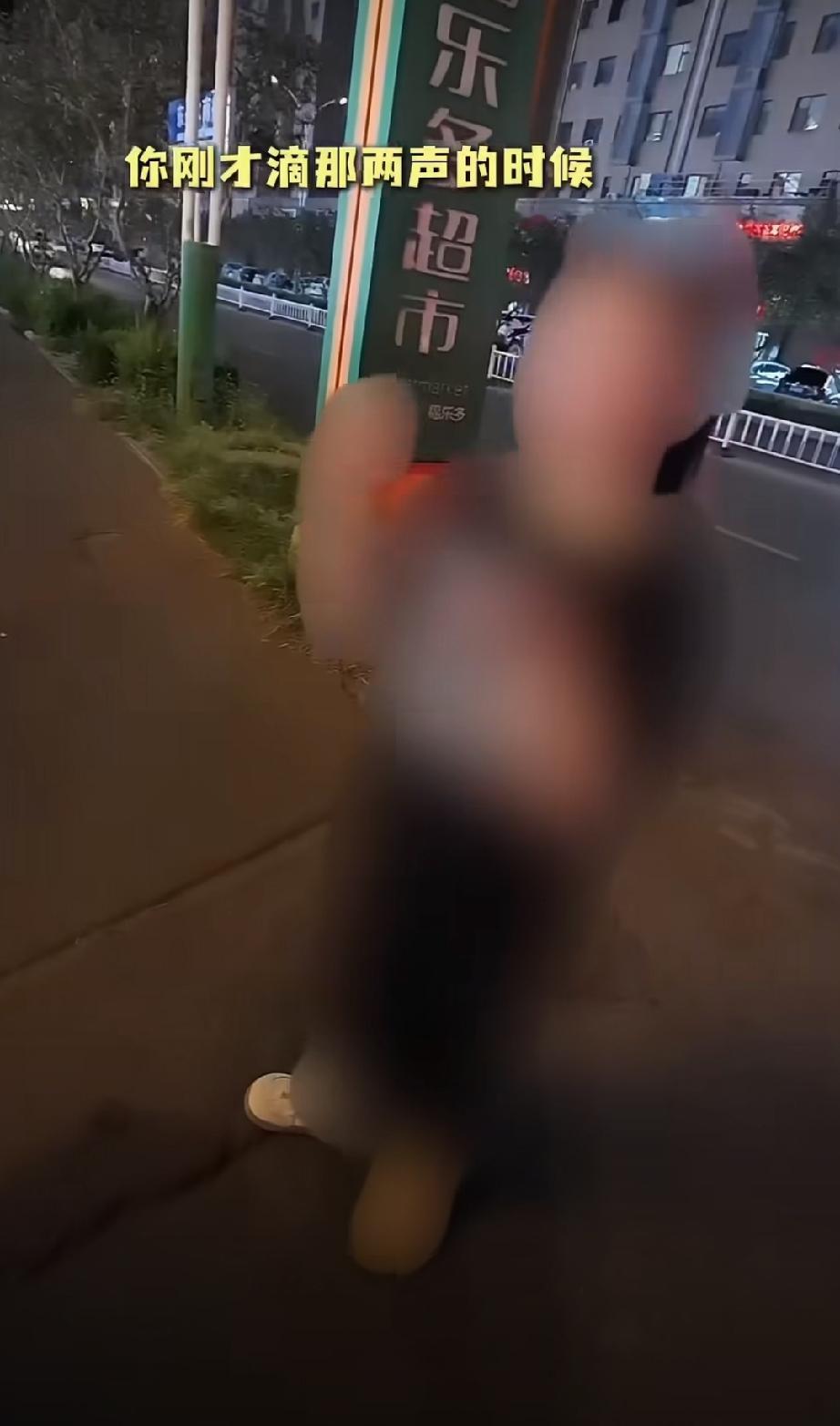 女子路口低头玩手机挡路，男子骑电动车怕喇叭声吓到她，口头“滴滴滴”出声提醒，并且