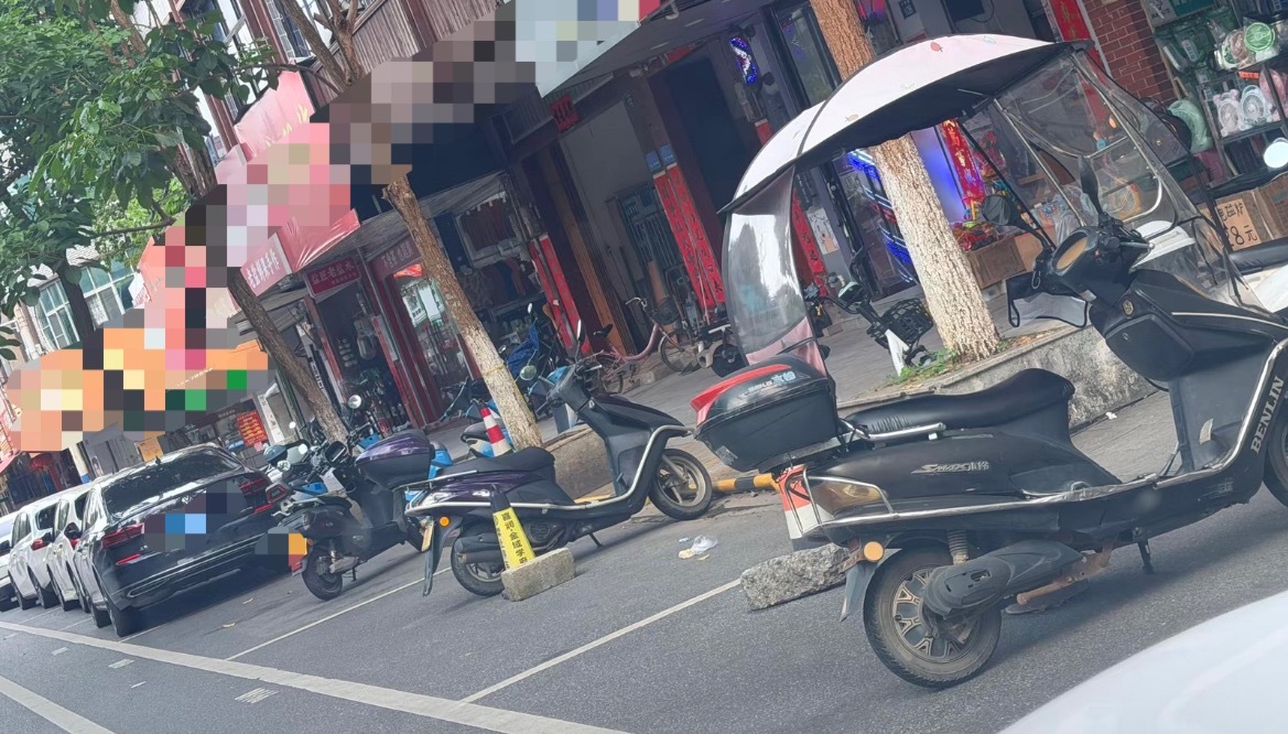 近日，多名网友反映：玉林石南路边停车位被电车和石块占了。同城热点创作计划 玉林·