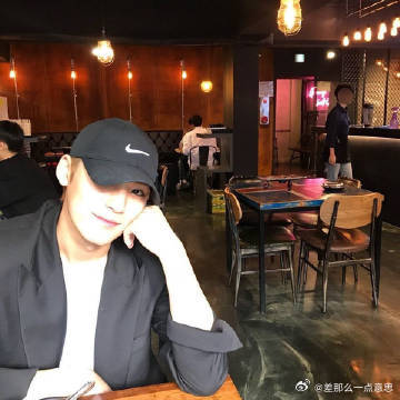 金珉奎不明显上班头像金珉奎工位抓拍背影图，帽子罩住脑袋，背着书包安静坐在工位。生