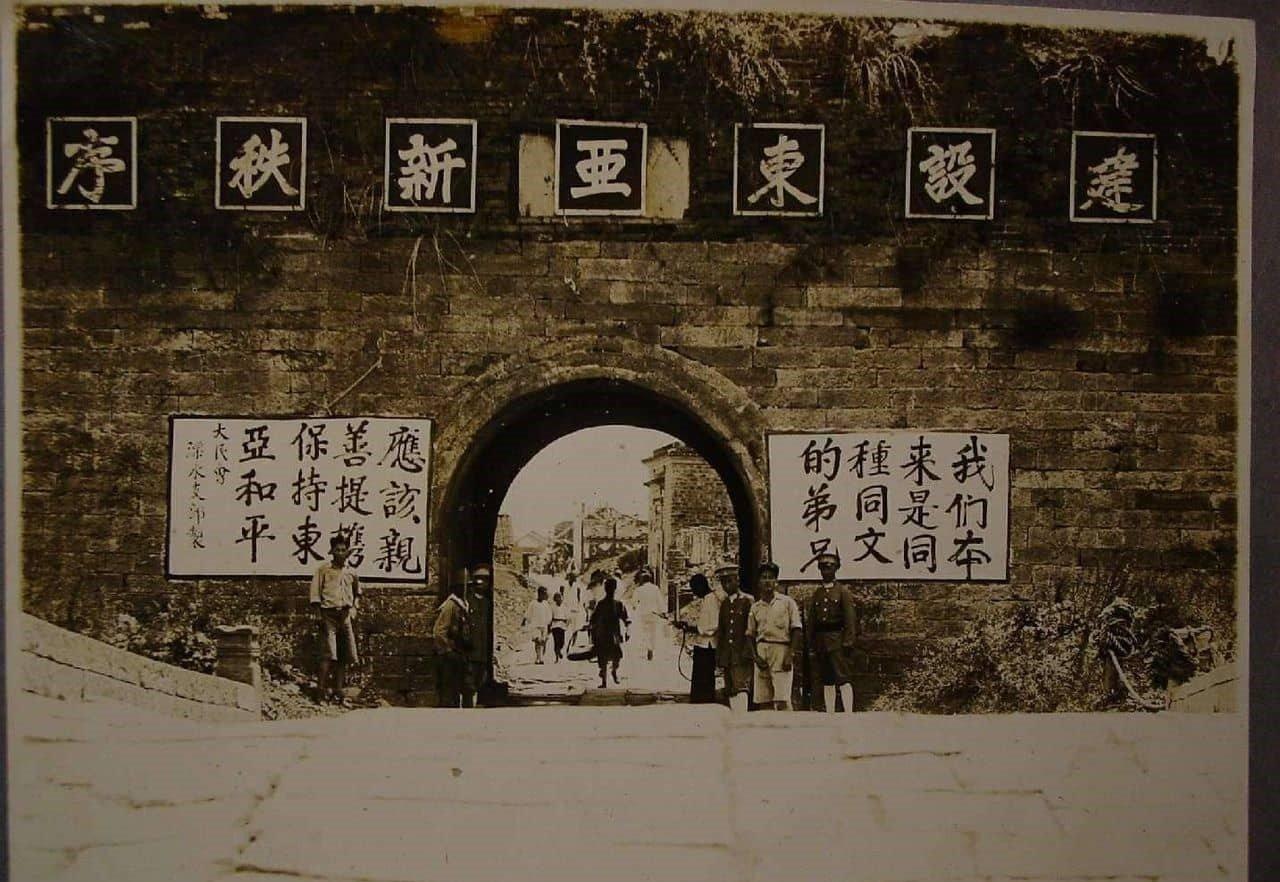 这张照片反映的是日本侵华期间在占领区的城门放置的宣传标语:
建设东亚新秩序
我们