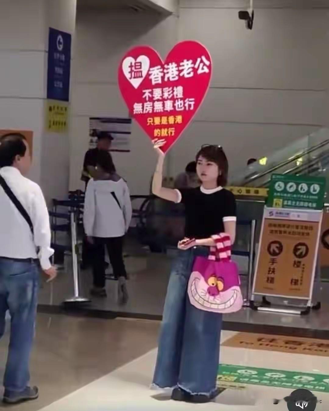 这名女子疑似在口岸显眼的位置高举牌子，点名要找一位香港户籍的老公，并且不要彩礼也