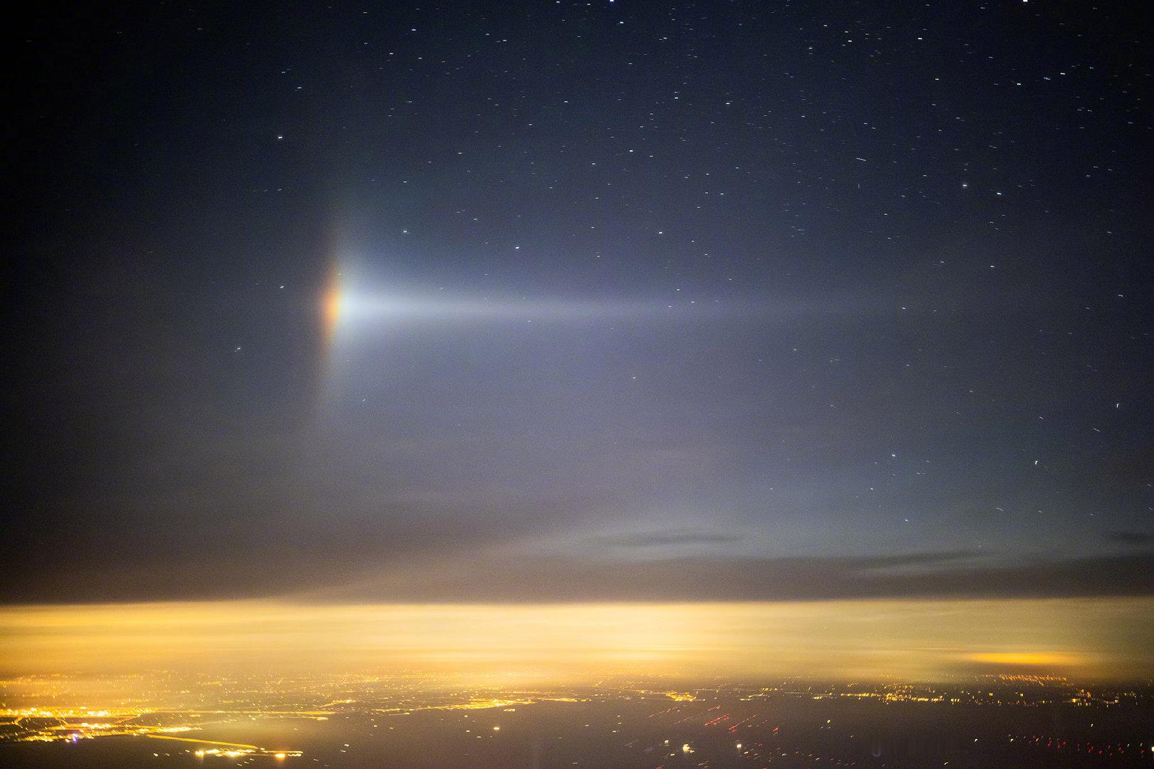 夜航的舷窗外，月光穿透高空的薄云，与云中无数的细小冰晶相遇。它们合力将清辉折射，