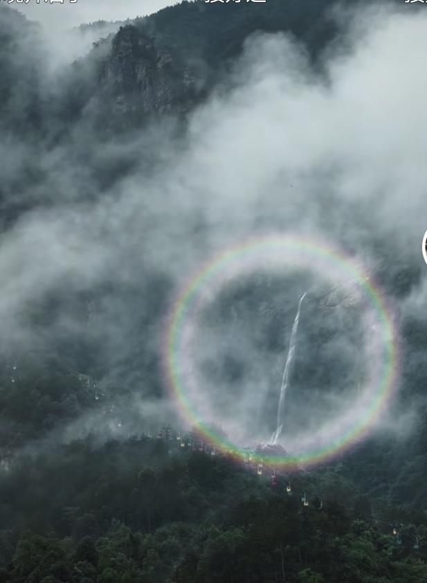 庐山瀑布上空出现罕见完整圆形彩虹，环形彩光环住飞流瀑布，山间云雾翻涌，画面如梦似