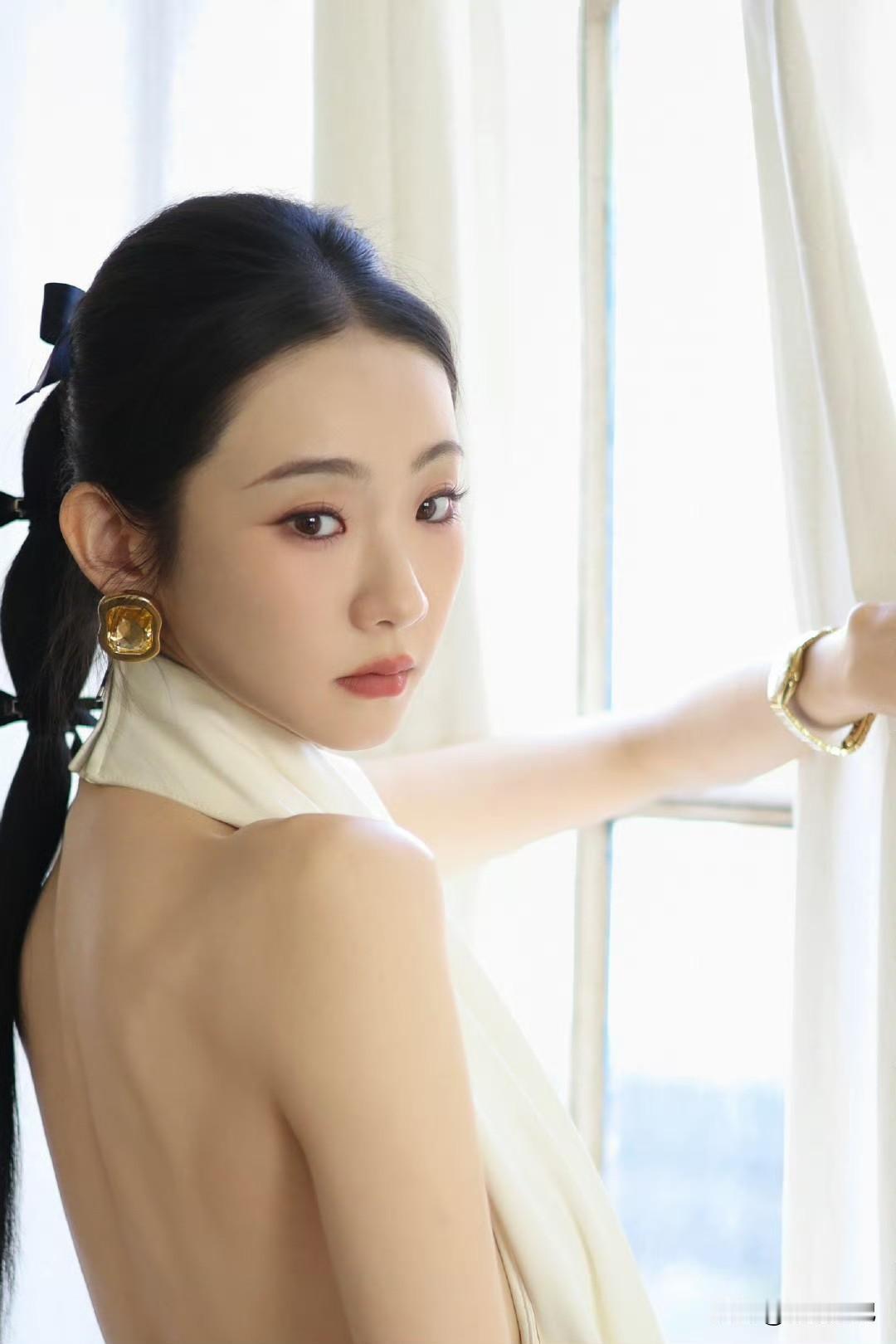 张艺凡  白裙滑落肩头，香肩半露，玉背如凝脂铺展，这肩背间的弧度，是揉碎了月光的