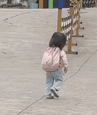 小女孩背着书包，独自一人向学校门口走去的背影，给人留下难忘的印象！能够看得出来，