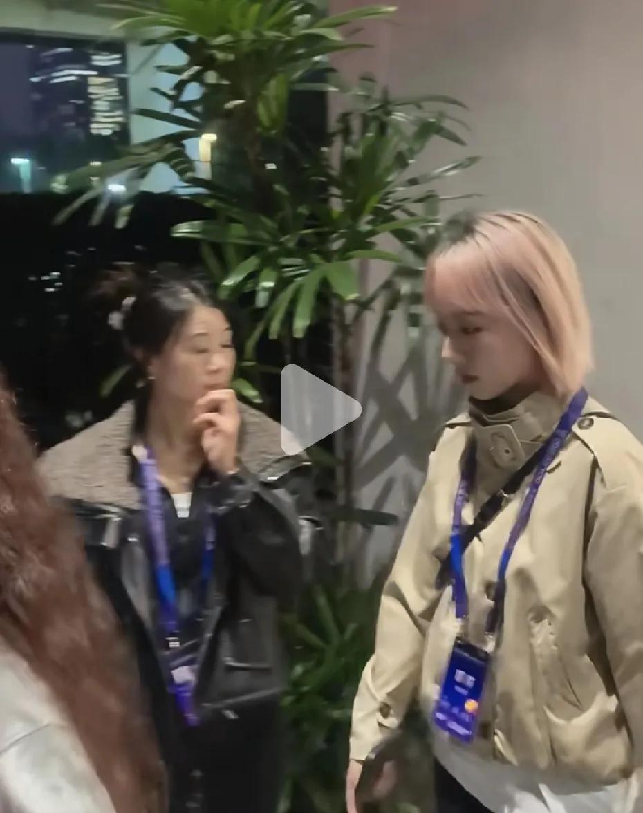 看到石宇奇训练馆边上的身影了吗？
不是教练。
是个染着同款灰金色头发的姑娘，端着