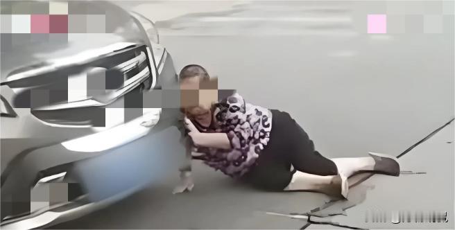辽宁沈阳，大妈看路边停放了一辆好车，用身体蹭上车灯，然后就躺在车前面，静等着司机