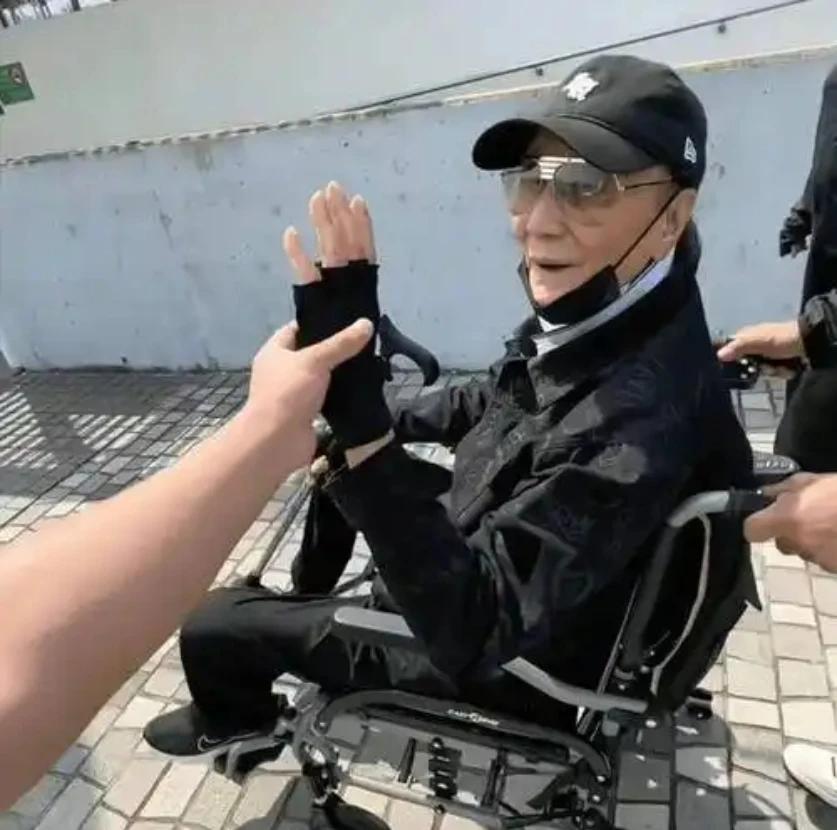 89岁的谢贤身体机能明显衰退，出行需4名护工轮流搀扶，轮椅与拐杖成为日常伴侣。尽