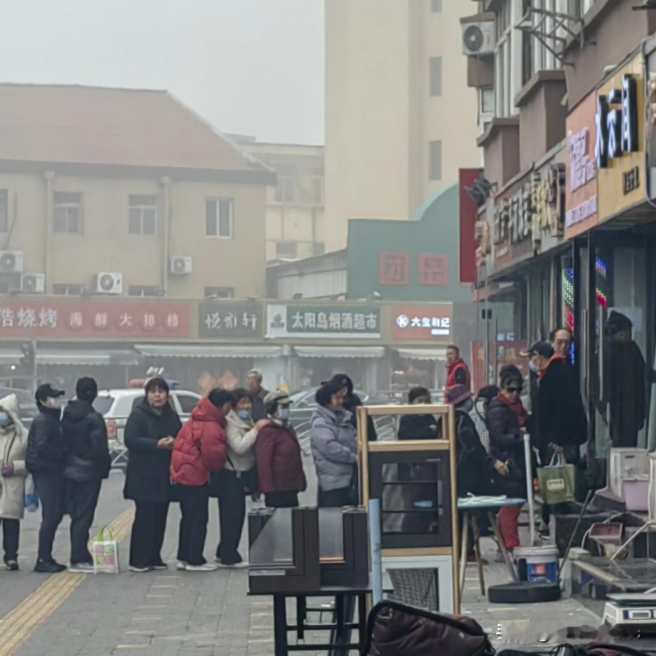 今天是个大雾天，到了十点雾气还很重。明天就是二月二龙抬头了。团岛市场周边，老年人