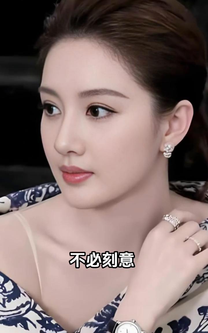 她身披青花披肩，如水墨长卷铺展，珠饰与钟表点缀，平添几分贵气。眉眼清冷而温润，举