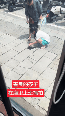 小小的身影，藏着最珍贵的善良

行走在路上，女孩发现路面地砖破损松动，连忙蹲下去