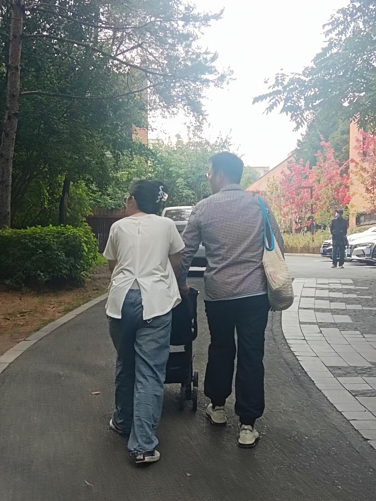 周末公园里看到这对小夫妻推着婴儿车，就拍了下来，
 女孩推着婴儿车，男孩扶着车背