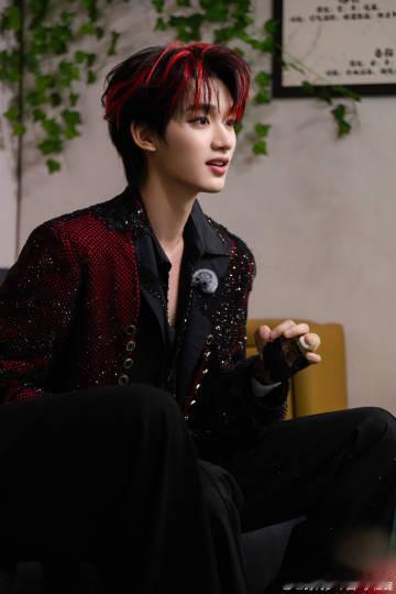 丁程鑫红黑挑染贵气登场聚光落于身前，红黑挑染撞出独特气场。酒红色亮片西装衬得身姿