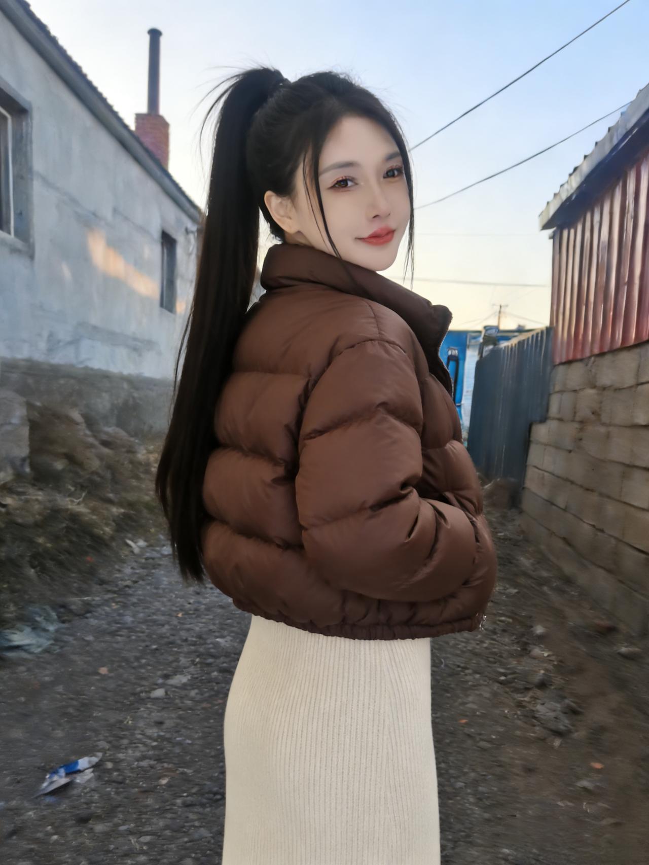 颓垣矮巷沐残阳，尘陌风轻拂鬓长。
棕袄暖披凝暮色，素裙轻曳漾流光。
眸中清彻涵千