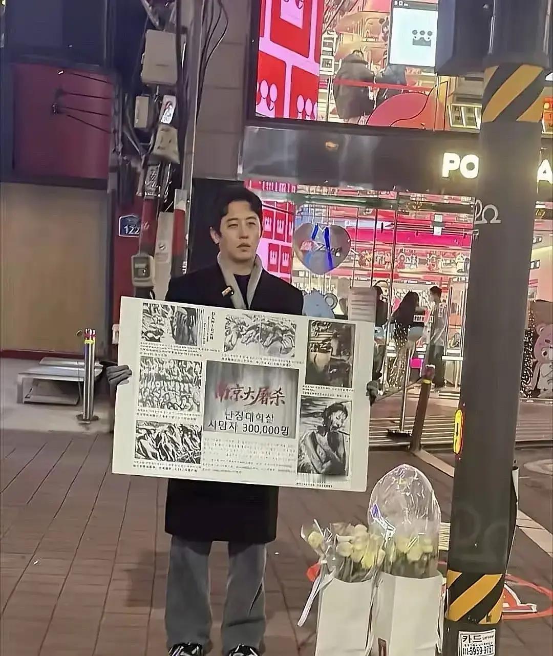 零下首尔的街头，冷风像刀子刮脸。
 
一位韩国小伙举着牌子，韩文写着“南京大屠杀